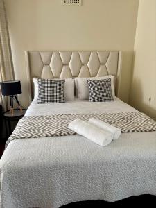 a bed with two pillows and two towels on it at Rephidim Palace in Durban
