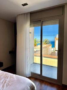 a bedroom with a sliding glass door to a balcony at Duplex trouville à 2 pas de la plage in 'Aïn el Turk