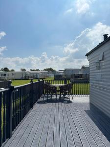 eine Terrasse mit einem Tisch und Bänken auf einem Deck in der Unterkunft Family-Friendly 3-Bed Caravan Recently Renovated on Seven Bays Holiday Park, Padstow in Saint Merryn + 15 Fotos