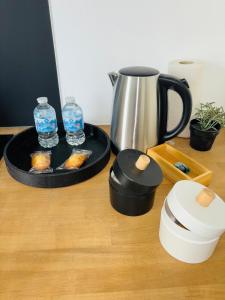 a table with a coffee pot and a tray with water bottles at Le 32 - Studio rénové - Centre in Coudekerque-Branche