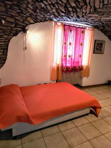 - une chambre avec un lit rouge et une fenêtre dans l'établissement Lo Tatà - Maisons de Charme - Caratteristico Appartamento a 2 passi da Courmayeur, à Pré-Saint-Didier 41 autres photos