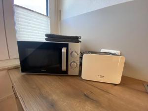 a microwave and a toaster oven sitting on a floor at Küstenbude Ostseestübchen in Grömitz