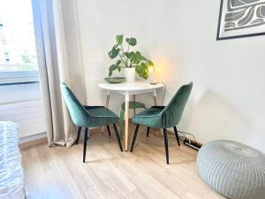 a table with two chairs and a table with a plant at Central city apartment in Zurich! in Zürich