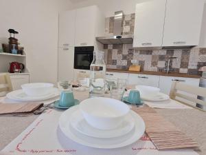 a table with white plates and glasses on it at La Chicca di Milu' for Pet Lovers in Alcamo