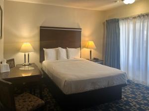 a hotel room with a bed and a desk and two lamps at Oceanside, CA – Marina / Camp Pendleton in Oceanside