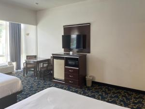 a hotel room with a bed and a desk with a television at Oceanside, CA – Marina / Camp Pendleton in Oceanside