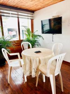 a table and four chairs in a room with a tv at Cabaña Dulce Encanto in Villeta +10 photos
