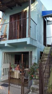 a person sitting on a couch under a balcony at Recanto do Sossego II - Sheriff's House in Santa Cruz do Sul