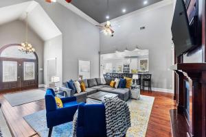 a living room with a gray couch and blue chairs at Downtown Estate Luxury Property in Hammond +48 photos