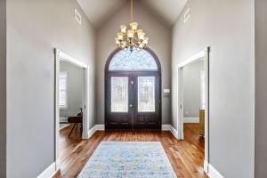 an empty room with a door and a chandelier at Downtown Estate Luxury Property in Hammond