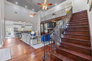 a staircase in a living room with a ceiling fan at Downtown Estate Luxury Property in Hammond