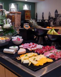 a counter with cheese and other foods on a table at Hôtel Couvent du Franciscain Centre ville in Strasbourg