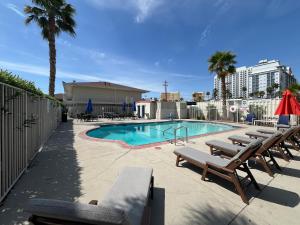 einen Pool mit Liegen und Stühlen neben einem Gebäude in der Unterkunft Motel 6 Las Vegas, NV - Strip in Las Vegas