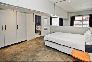 En eller flere senge i et værelse på Rustic Industrial Maboneng Loft + 8 billeder