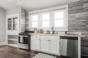 a kitchen with white cabinets and a stove at 4BD near Indy 500 Speedway - BBQ & Backyard in Indianapolis