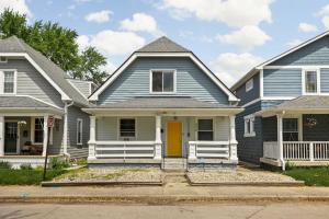 a blue house with a yellow door on a street at 4BD near Indy 500 Speedway - BBQ & Backyard in Indianapolis