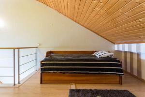 a bed in a room with a wooden ceiling at MariaHouse in Faro