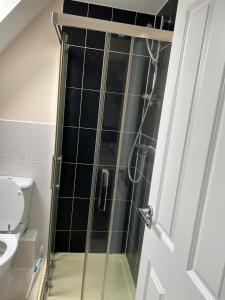 a shower with a glass door in a bathroom at Tuffley 4 bedroom house in Quedgeley