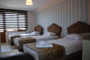 A bed or beds in a room at Selimiye Hotel