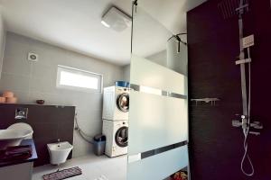 a bathroom with a washing machine and a sink at Bandiland Szigetmonostor Horány in Szigetmonostor +26 photos