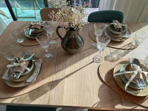 a wooden table with plates and a vase of flowers at MedanoJoy1- 3 bedrooms, spacious apartment 60 m from the beach in El Médano