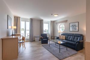 a living room with a couch and a table at Bina an der Seebrücke Zingst in Zingst
