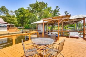 een patio met een tafel en stoelen op een houten terras bij Lake Talquin Cabin Close to FSU and Quincy! in Quincy
