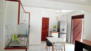 a kitchen with a table and a counter top at Spacieux bas de villa in Les Abymes