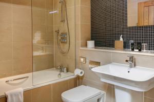 La salle de bains est pourvue d'un lavabo, de toilettes et d'une douche. dans l'établissement Quy Mill Hotel & Spa, Cambridge, à Cambridge