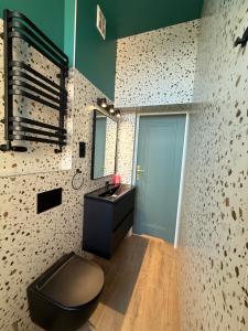 a bathroom with a black sink and a blue door at Vintage Rooms in Przemyśl +30 photos
