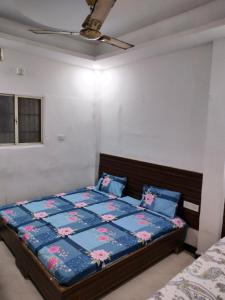 a bedroom with a bed with a blue comforter at Shiv Raje in Ujjain
