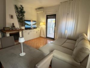 a living room with a couch and a television at Casa Home COMPIANI Apartment in Isola Sacra