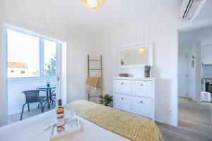 una camera da letto con un letto, un comò e una finestra di Casa da Vila a Vila do Bispo