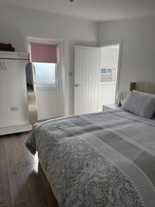 a bedroom with a bed and a room with a door at Kittsmead in Cowden