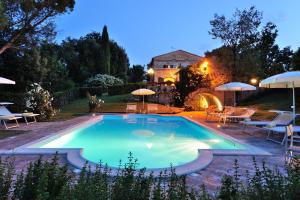 Montemaggiore al MetauroにあるItalian Experience-Villa Ariaのテーブルとパラソル付きの庭のスイミングプール