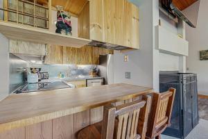 Una cocina con gabinetes de madera y encimera. en Loon Mountain Nest, en Lincoln 13 fotos más