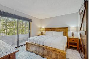 Un dormitorio con una cama y una ventana grande en Loon Mountain Nest, en Lincoln