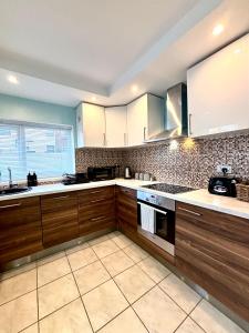 a large kitchen with wooden cabinets and appliances at Modern Art House - serviced accomodation in Liverpool +33 photos