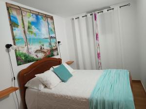 a bedroom with a bed with a painting on the wall at Casa da Tulipa in Cabo Branco