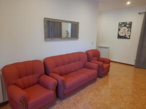 a living room with two leather couches and a mirror at Amarante Residence in Amarante