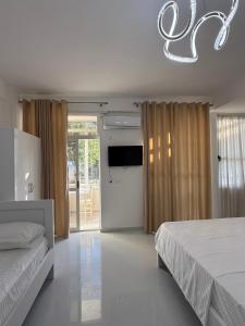 a bedroom with two beds and a flat screen tv at ELIO's Room in Durrës