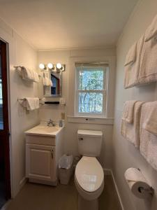 a bathroom with a toilet and a sink and a window at Yardarm Motel in Searsport +85 photos