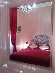 a bedroom with a red bed with a large mirror at Locanda Villa Moderna in Genoa
