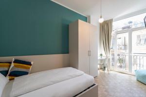 a bedroom with a white bed and a blue wall at Stay COOPER l Capitol Rooms in Bolzano
