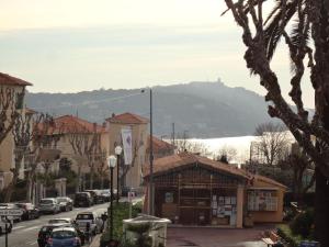 a small building on a city street with cars parked at Hotel La Regence in Villefranche-sur-Mer