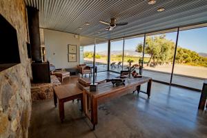 a living room with a table and a large window at LAR Valle de Guadalupe in El Porvenir
