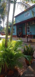 a blue house with palm trees in front of it at Arai Apart Iguazu in Puerto Iguazú