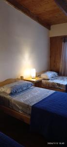 a bedroom with two beds and a lamp on a table at Arai Apart Iguazu in Puerto Iguazú
