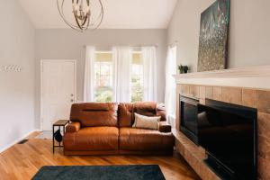 a leather couch in a living room with a fireplace at Cozy Retreat - King Beds - Cinema Cave & Home Gym in Westminster +46 photos