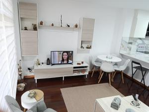 a living room with a tv and a table and chairs at Cruz de Baixar in Fisterra